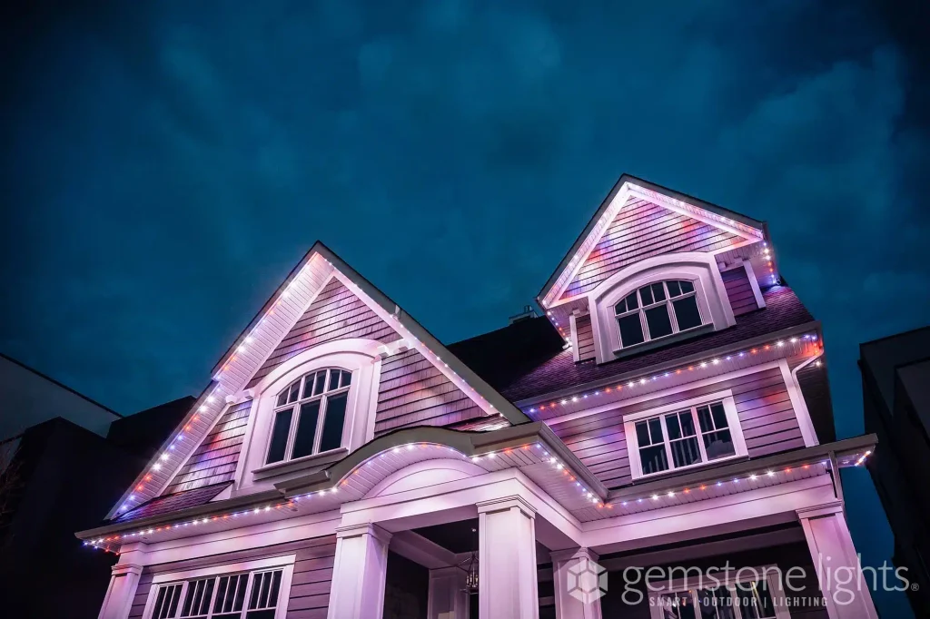 A charming house is adorned with colorful lights against a moody sky