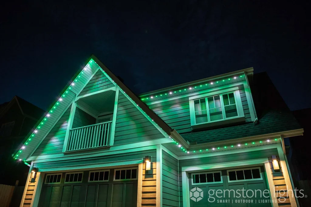 A cozy home is illuminated with vibrant green lights against a night sky