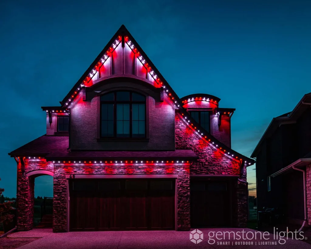 A beautifully lit house showcases vibrant red and white decorative lights against a twilight sky