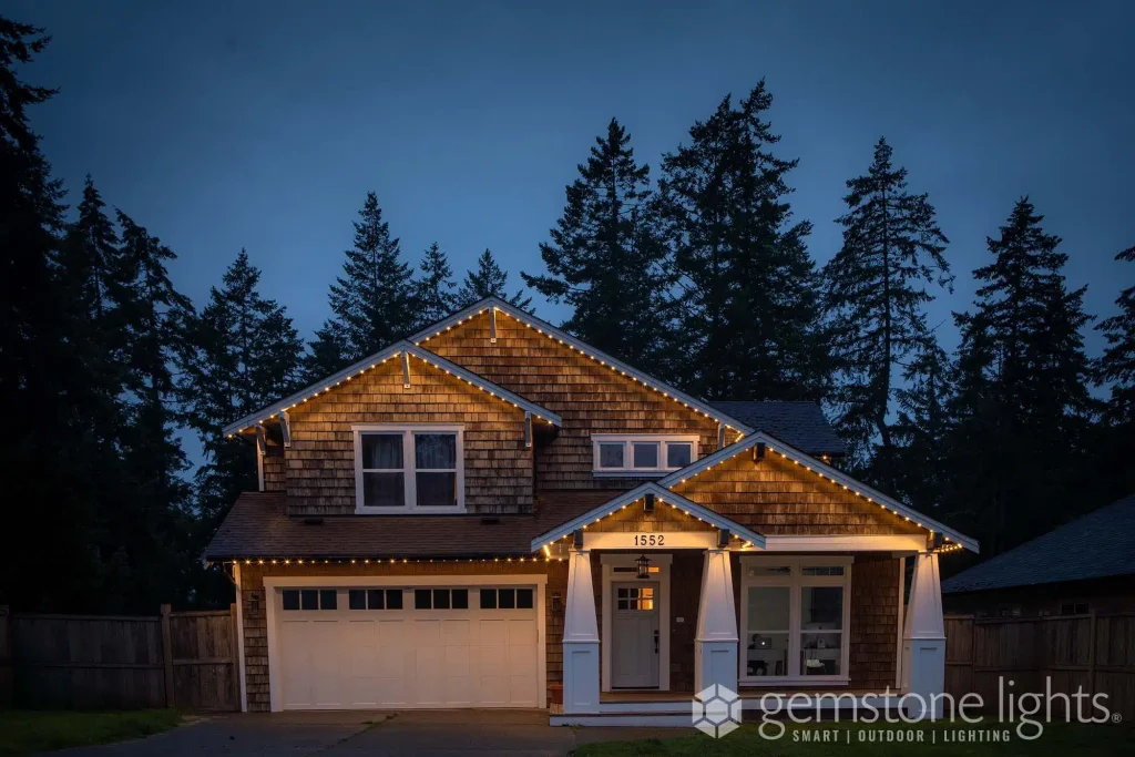 A cozy house is adorned with festive lights under a twilight sky