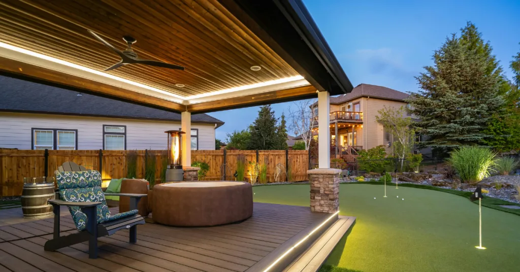 A cozy outdoor space features a hot tub, golf putting green, and lounge area